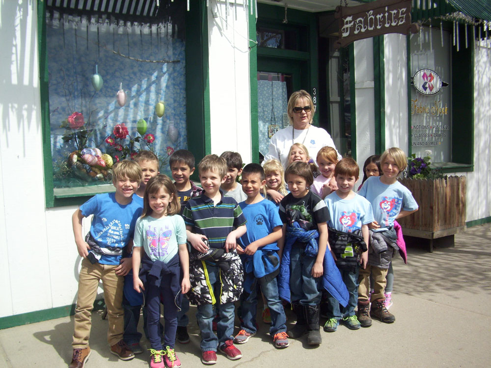 Mrs. Green poses with her class outside the store.