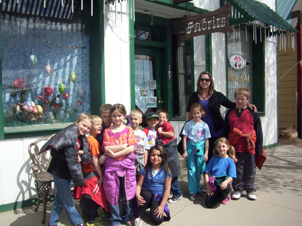 Mrs. Linke poses with her class outside the store.