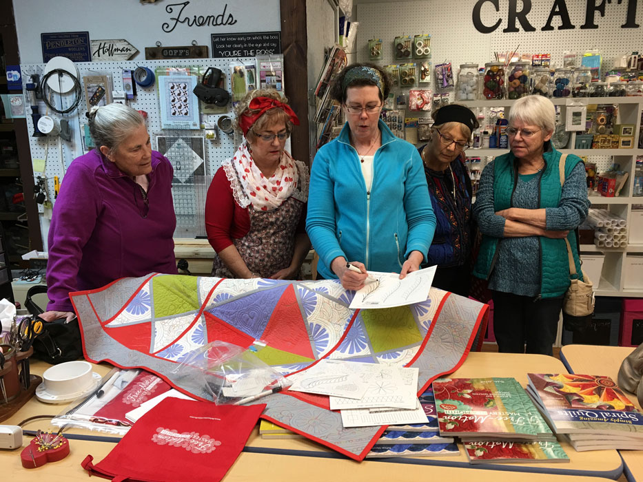 ReNae Merrill demonstartes the process to several Fabric Nook customers.