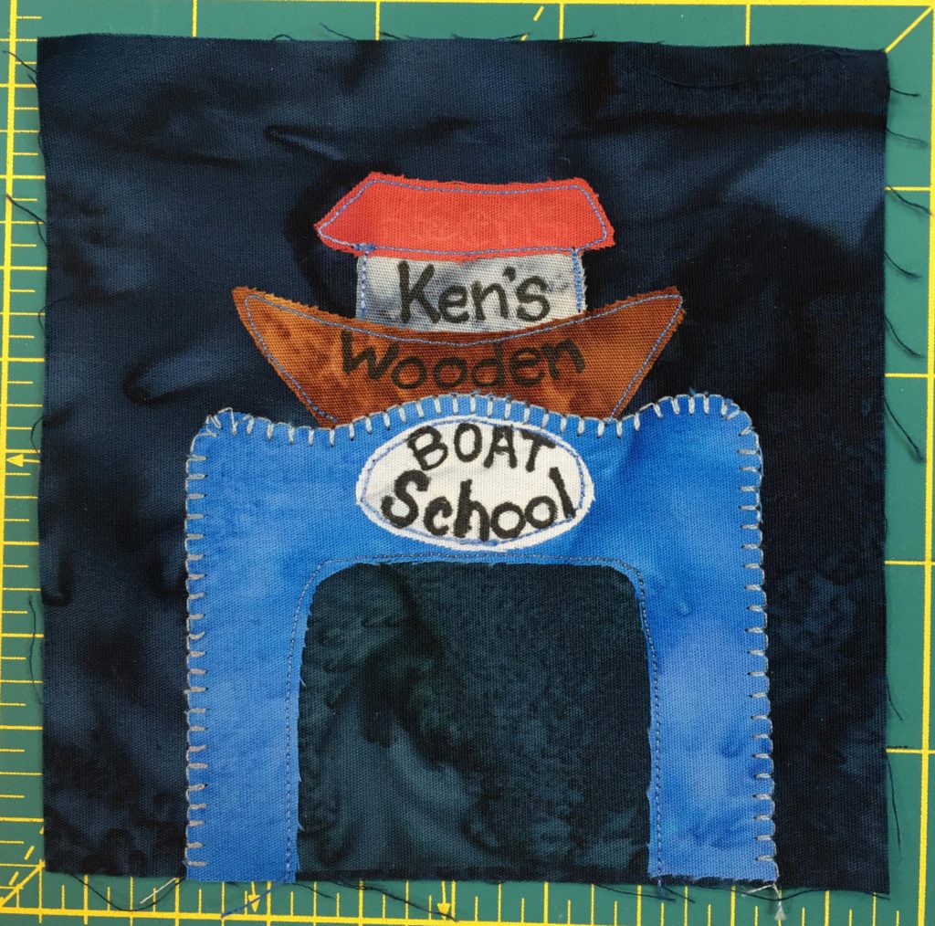 This block shows a blue structure with a boat on top. The boat has a brown wooden hull, and looks a bit like Noah's ark with a red roof. On the boat and building big letters read,