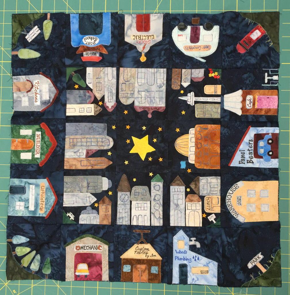 The quilt being made with the second round done. All the previous buildings are in the quilt surrounding a central star.