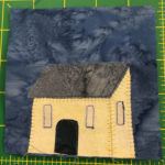 This light yellow house is just a simple square house with an angled roof. It has three windows, one on the side, and a black rounded door on the front in the center.