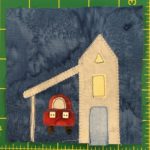 This quilt block shows a tall skinny building with a triangular roof. It has two windows, the top being a triangle as well. Attached to the left of it is a covered car port where a red car is parked.
