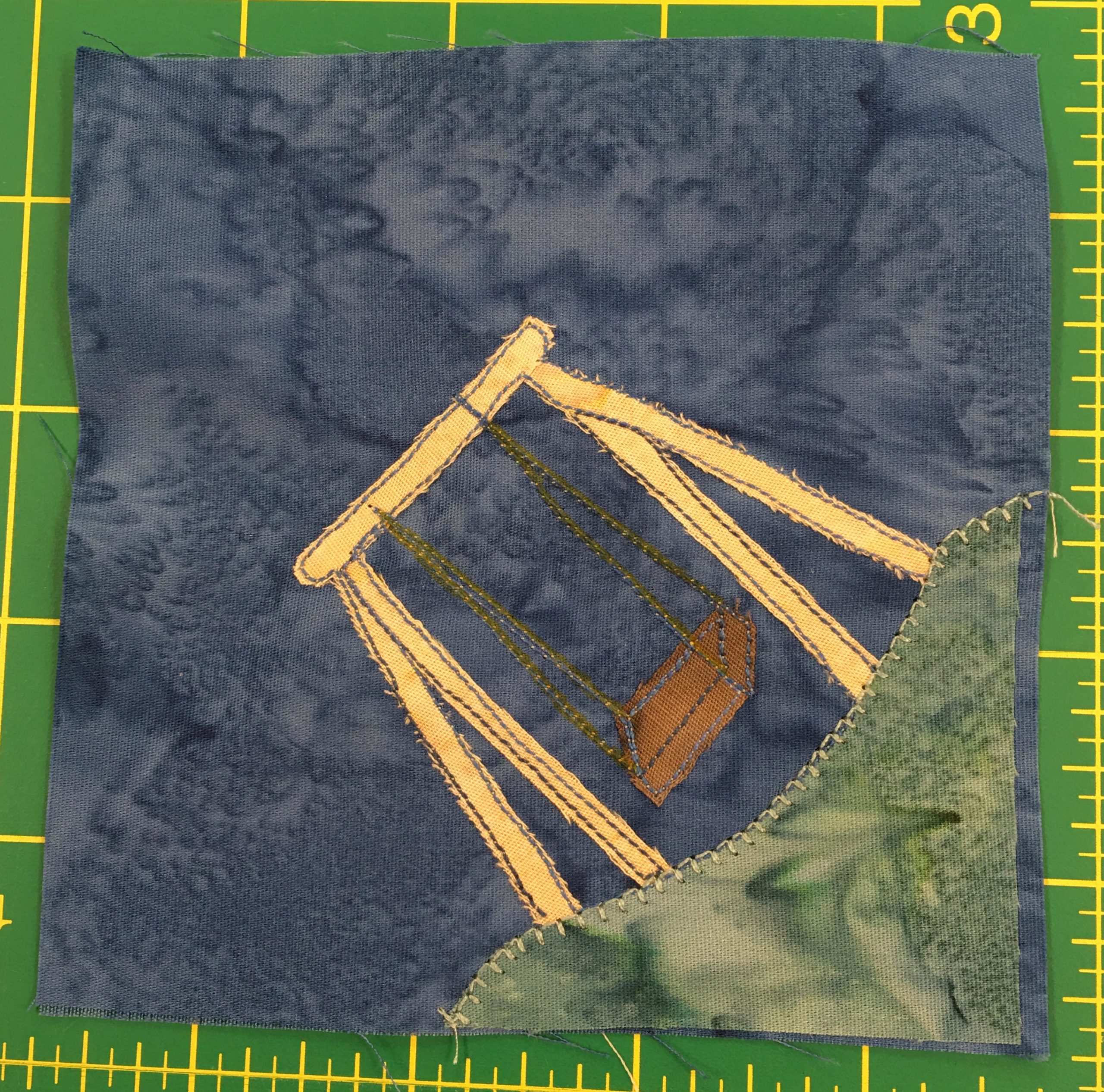 This block shows a patch of grass in the bottom right corner. On the patch of grass is a big wooden swingset with a solitary swing.