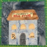 This quilt block shows a tall building with a trapezoid shaped orange roof that has a sign on the front reading, 