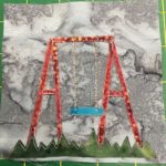 This quilt block shows another patch of grass at the bottom using a jagge piece of fabric with different shades of green on it. Against the gray background is a swingset with a singular swing hanging from it. The swingset itself is a striking red against the gray, while the chains are an interesting speckled thread. The set is speckled too. The seat itself is a light blue.