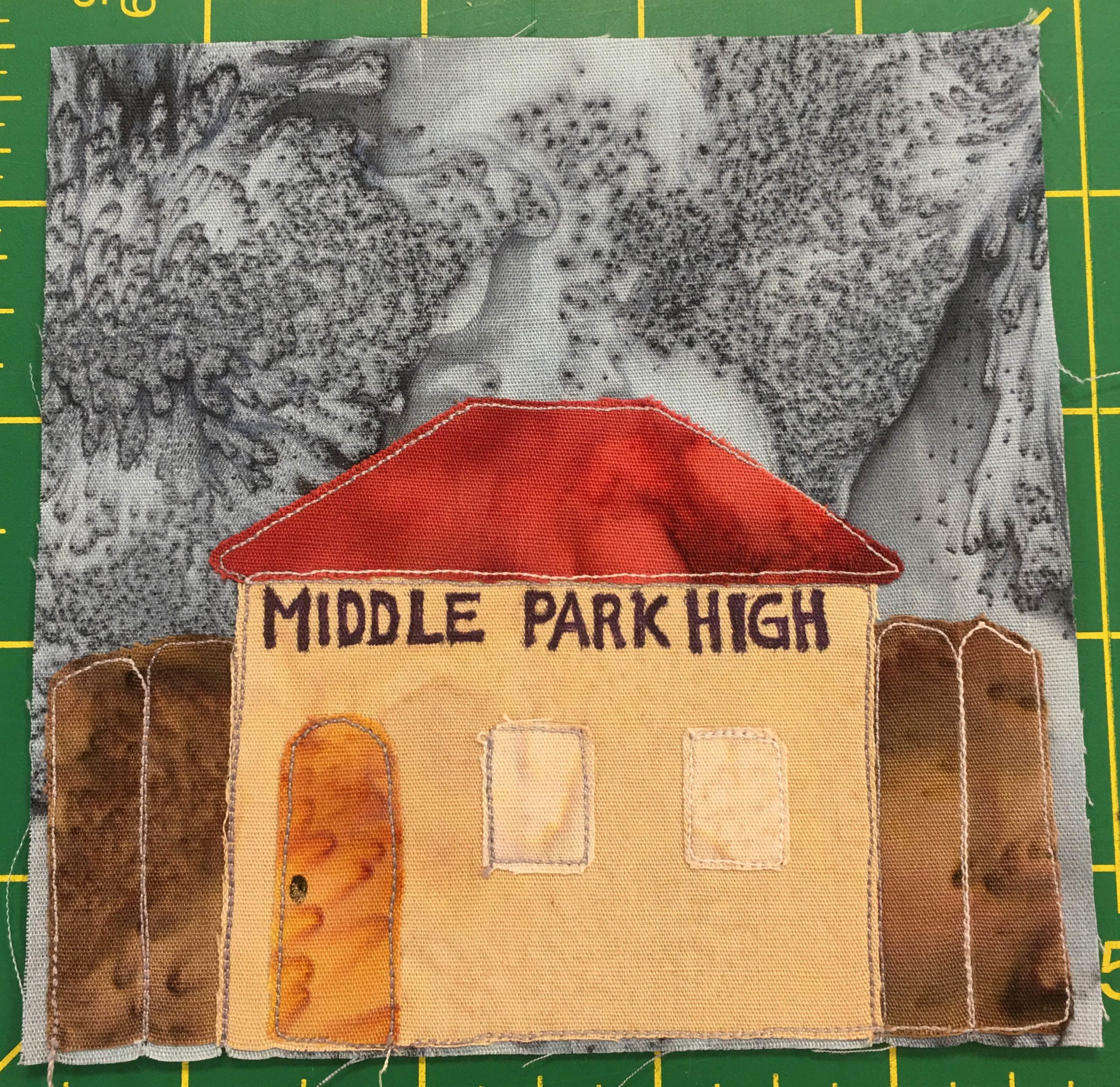 In this quilt block we have another light orange building bearing the words,