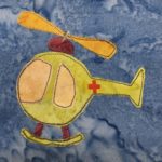 This block shows a round globular green helicopter with a first aid red cross on it. The propellers are yellow, and there are two large blades above the bubble. Below that is a deep red beanie cap like attachment that attaches the blades to the globe like body. The front of the ball has a large light yellow windshield, with a side door window next to it. This is all against a blue salmon-patterned background.