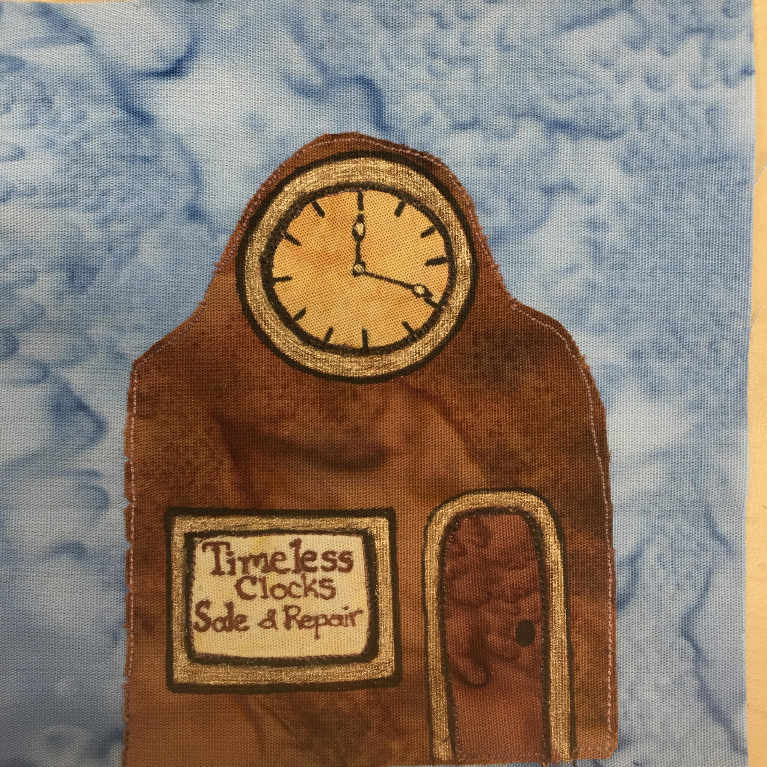 This quilt block shows a clock repair shop. it's shaped like an old mantel clock but with a bigger base, which is the rest of the building. Theere is a big clock face pointing 12:20 at the top of the roof. The building is all brown, like a wooden mantel clock. There is a window on the left and in it in brown letters reads,