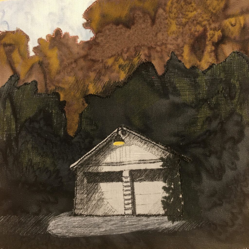 This quilt block shows a white garage and a lot of smoke. The garage is a white piece of fabric, with black pen markings on it to give it its details. There is drawn in a yellow lamp at the top of the garage, and the shadows are drawn in on two garage doors. Everywhere else except the upper left of the block is covered with a black fabric and brown fabric indicating smoke. It's quite dramatic.