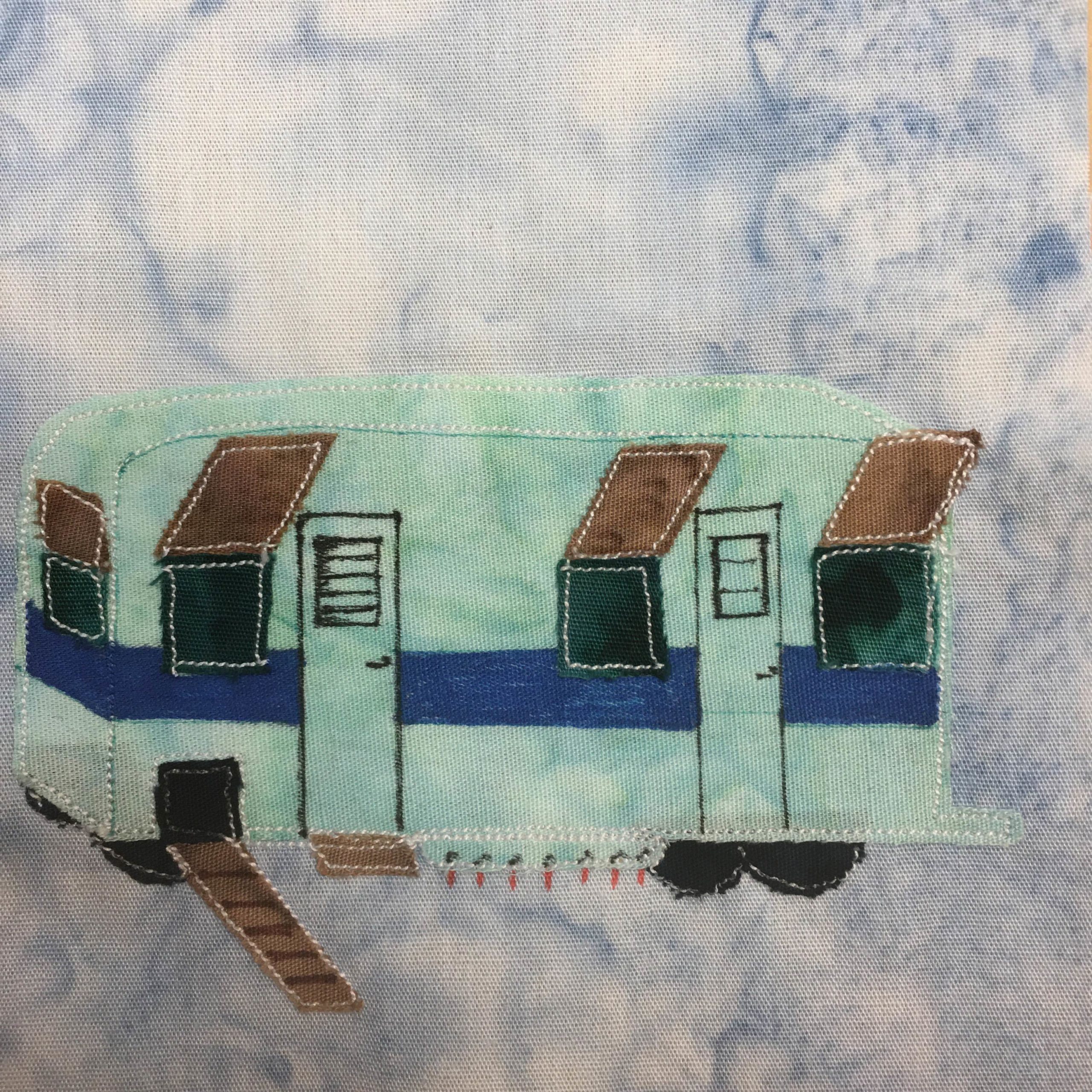 This quilt block shows a teal colored winne-eggo. This is a Winnebago decked out to be a chicken nest and watering hole. The steel fabric is shaped like a rectangular winnebago with dark green windows. The windows have covers that are open and are brown. Ther is a darker blue horizontal stripe across the middle of the Winnebago. There are drawn two human doors, and one ramp with a black square for chickens. Near the back wheels are little red nipples lined up to feed the chickens water on the bottom of the trailer.