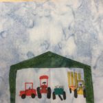 This quilt block shows a green shed with an open front opening. It's very wide and covers the whole lower part of the block. Inside the shed is equipment drawn with colored pens. There's a side-by-side, a tractor, a manure spreader, and a bale wagon. The manure spreader is a blue-green, the bale wagon is yellow, and the others are red.