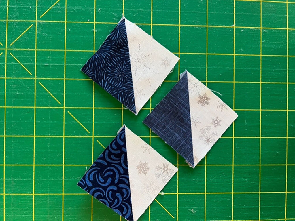 Finished blue and white half-triangle squares just ready for a quilt.